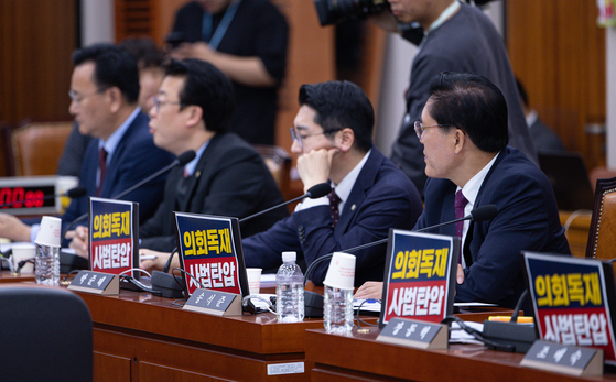 14일 오전 서울 여의도 국회에서 열린 법제사법위원회 전체회의에 참석한 국민의힘 의원들의 노트북에 '의회 독재·사법 탄압' 피켓이 붙어 있다. 뉴스1
