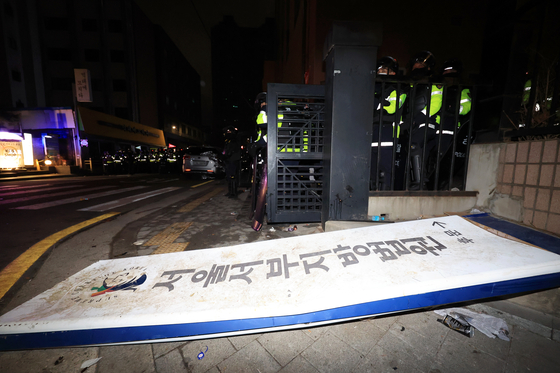 지난 1월 18일 윤석열 대통령이 내란 우두머리 혐의로 구속되자 지지자들이 서울 마포구 서울서부지방법원에 난입한 뒤 서부지법 후문 현판이 쓰러져 있다. 연합뉴스