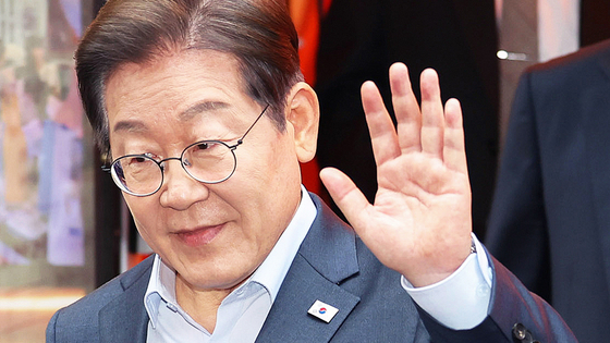 이재명 더불어민주당 대선 후보가 1일 서울 종로구의 한 포차 식당에서 '당신의 하 루를 만드는, 보이지 않는 영웅들'이란 주제로 열린 배달 라이더, 택배 기사 등 비(非)전형 노동자들과 간담회를 마친 뒤 나서며 손을 흔들고 있다. 김성룡 기자