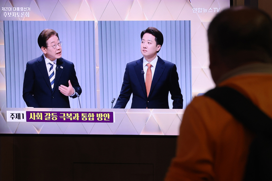 한 시민이 지난 23일 서울역 대합실에서 제21대 대통령 선거 2차 후보자 토론회에 출연한 이재명 더불어민주당(왼쪽), 이준석 개혁신당(오른쪽) 후보의 토론을 시청하고 있다. 연합뉴스