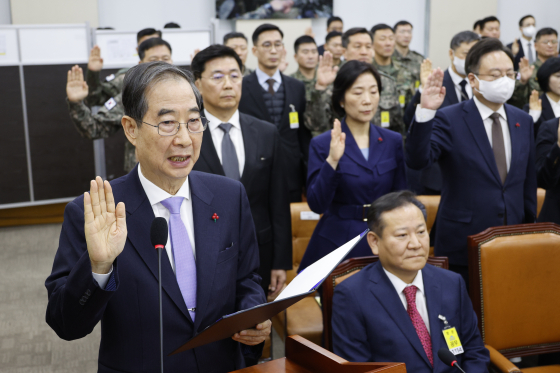 한덕수 당시 국무총리가 1월 22일 오전 서울 여의도 국회에서 열린 윤석열 정부의 비상계엄 선포를 통한 내란 혐의 진상규명 국정조사 1차 청문회에 출석해 증인 선서를 하고 있다. 이상민 당시 행정안전부 장관은 선서를 거부한 채 앉아 있다. 뉴스1