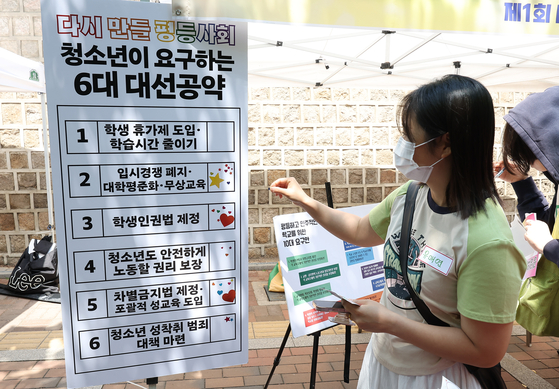 25일 서울 중구에서 열린 ‘다시 만들 세계포럼’에서 한 참가자가 청소년들이 원하는 대선공약에 스티커를 붙이고 있다. [연합뉴스]