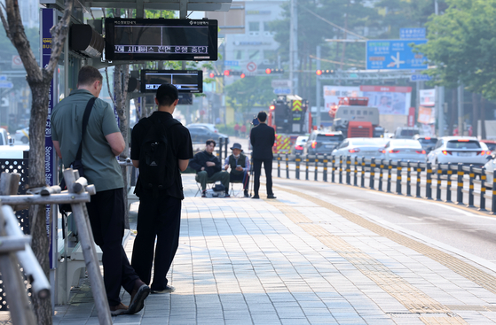 부산지역 시내버스가 전면 파업에 돌입한 28일 오전 부산 부산진구 롯데백화점 서면점 앞 버스정류장에서 시민들이 대체버스를 기다리고 있다. 사진 연합뉴스