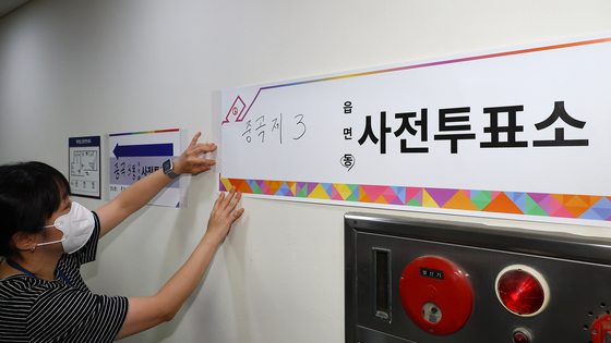 제21대 대통령 선거 사전투표를 하루 앞둔 28일 서울 광진구 중곡3동 주민센터에 마련된 사전투표소에서 관계자들이 안내판을 붙이고 있다. 김현동 기자