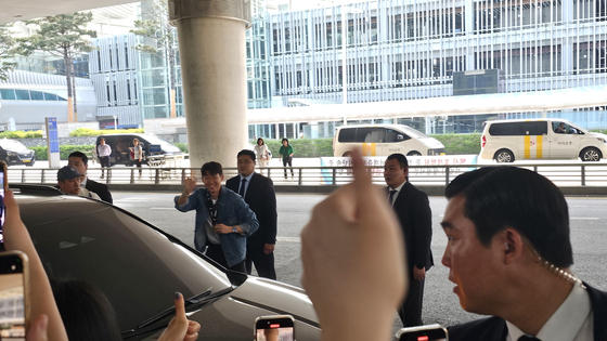 차량 탑승 전 우승 메달을 목에 걸어 보이는 손흥민. 연합뉴스