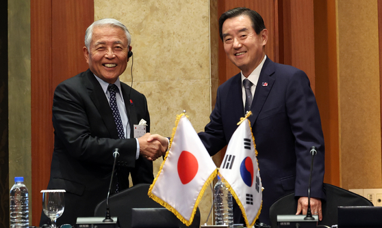 김윤 한일경제협회 회장과 일본 측 단장인 아소 유타카 아소시멘트 회장이 28일 오후 서울 중구 롯데호텔에서 열린 제57회 한일경제인회의 페회식에서 공동성명 채택에 앞서 악수를 하고 있다. 뉴스1