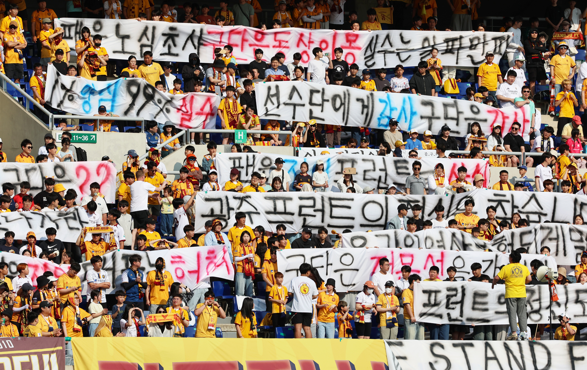 지난 25일 K리그1 광주FC와 강원FC의 경기가 열린 광주월드컵경기장. 광주 서포터즈들이 광주FC의 아사니 선수 연대기여금 미납 및 FIFA 징계 인지 못 한 사안과 관련해 항의하는 현수막을 펴들고 있다. [연합뉴스]