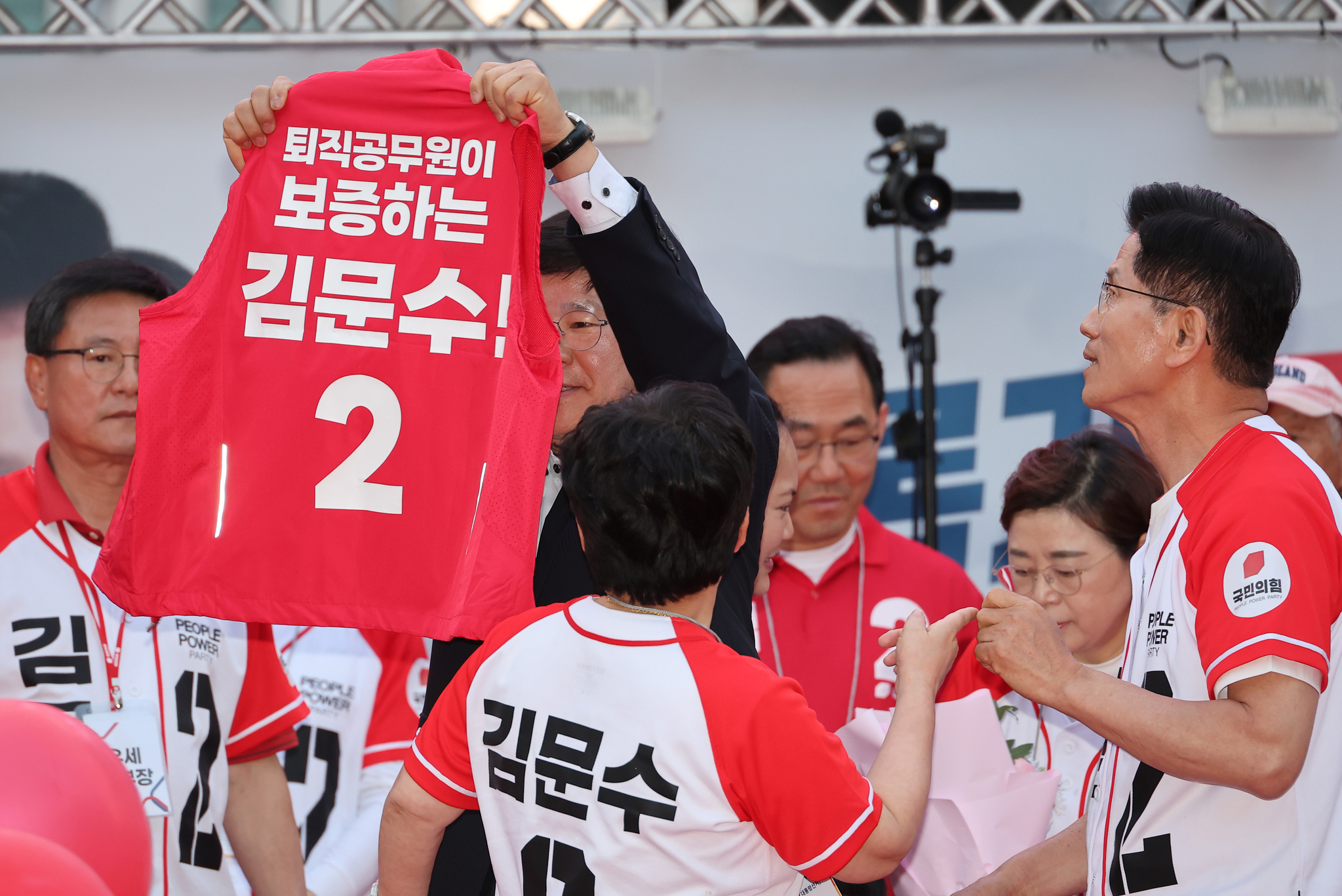 김문수 국민의힘 대선후보가 31일 경북 포항 북포항우체국 앞에서 열린 유세에서 ‘퇴직공무원이 보증하는 김문수’라고 적힌 조끼를 전달받고 있다. 연합뉴스