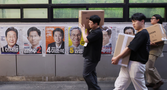 제21대 대통령선거 사전투표 둘째 날인 30일 서울 중구 소공동주민센터에 마련된 사전투표소에서 사전투표사무원들이 관내 사전투표함과 관외 사전투표지를 이송하고 있다. 연합뉴스