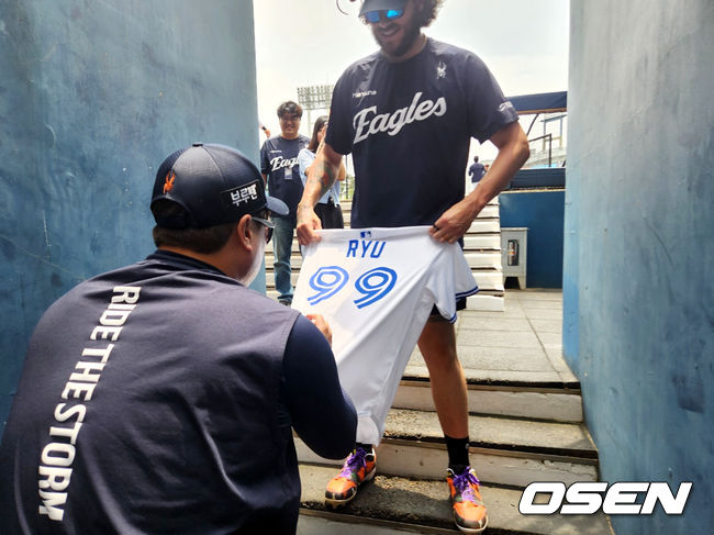 [OSEN=창원, 이상학 기자] 한화 류현진(왼쪽)이 31일 창원NC파크에서 코디 폰세가 팬에게 선물로 받은 토론토 시절 유니폼에 사인을 받고 있다. 2025.05.31 /waw@osen.co.kr