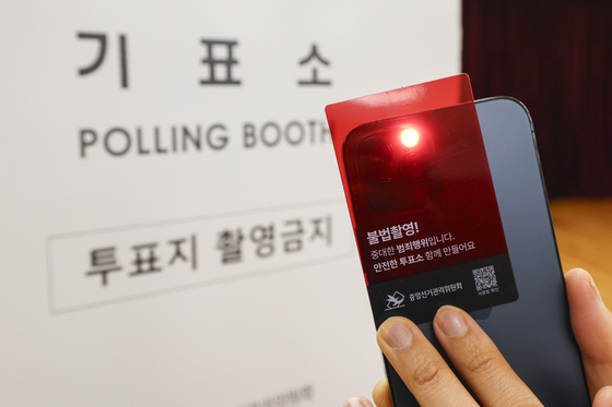 제21대 대통령 선거를 하루 앞둔 2일 서울 용산구 청파도서관에 마련된 청파동 제1투표소에서 투표소 관계자가 선거관리위원회에서 배부한 불법 카메라 탐지 카드로 불법 카메라 점검을 하고 있다. 뉴시스