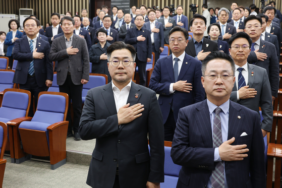 박찬대 더불어민주당 원내대표와 박성준 원내수석부대표가 지난 2일 서울 여의도 국회에서 열린 비상의원총회에서 국기에 경례를 하고 있다. 뉴스1