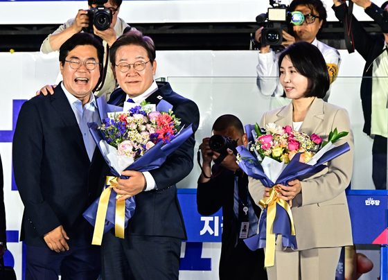 당선이 확실시된 이재명 더불어민주당 대통령 후보가 김혜경 여사와 4일 오전 서울 여의도 국회 앞을 찾아 박찬대 상임총괄선대본부장으로부터 꽃다발을 받고 있다. 뉴스1