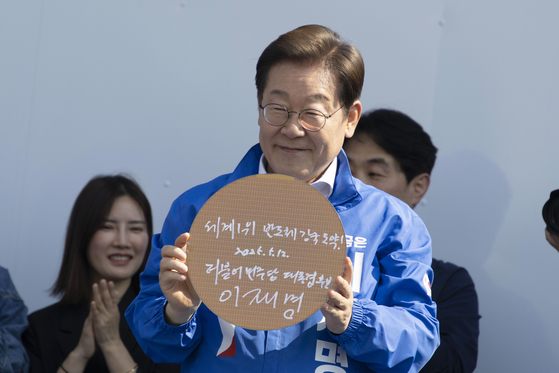 지난달 12일 오후 이재명 대통령(당시 더불어민주당 대선후보)가 12일 오후 경기도 화성시 동탄 센트럴파크 음악분수중앙광장에서 열린 ‘K-반도체' 동탄 집중유세에서 반도체 웨이퍼에 서명을 한 후 들어보이고 있다. 김성룡 기자.