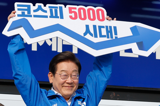 이재명 대통령이 대선 유세가 한창이던 지난달 29일 오후 서울 서초구 고속버스터미널광장에서 '코스피 5000시대'라고 적힌 피켓을 들고 있는 모습. 뉴스1