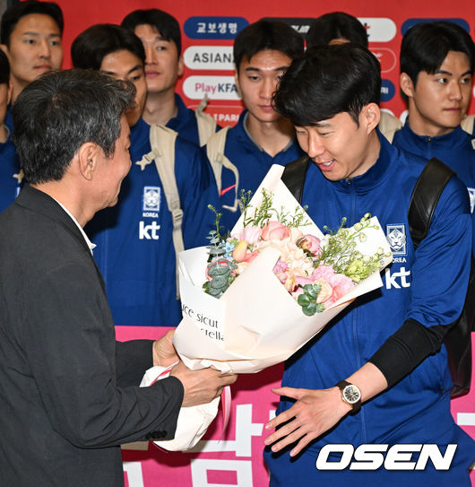 [OSEN=인천공항, 조은정 기자]월드컵 11회 연속 본선 진출에 성공한 한국 축구 국가대표팀이 6일 인천국제공항을 통해 이라크에서 귀국했다.한국은 6일 새벽(한국 시간)이라크 원정서 2-0 승리로 승점 19(5승 4무)점을 확보하면서 월드컵 11회 연속 본선 진출을 확정지었다.정몽규 대한축구협회장(왼쪽)이 축구대표팀 손흥민에게 꽃다발을  전달하고 있다. 2025.06.06 /cej@osen.co.kr