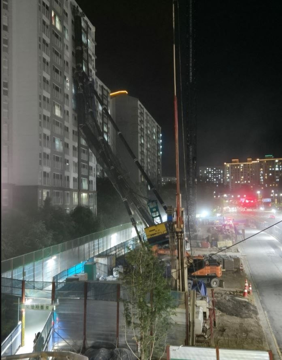 5일 오후 10시 13분쯤 경기도 용인시 기흥구 서천동 소재 인덕원~동탄 복선전철 공사 현장에서 중장비가 15층짜리 아파트 쪽으로 넘어졌다. 사진 경기소방본부
