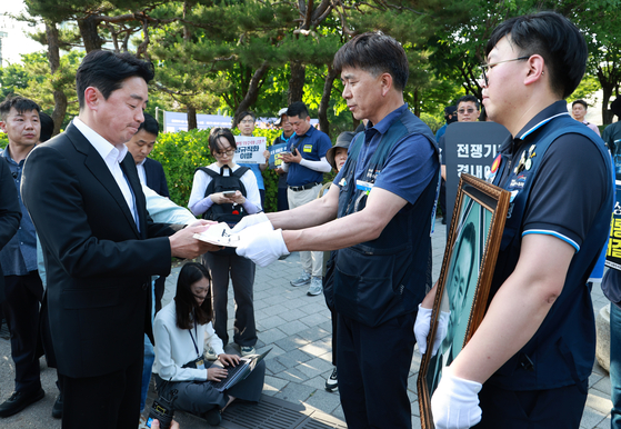 강훈식 대통령비서실장이 6일 서울 용산 대통령실 청사 인근 전쟁기념관 앞에서 태안화력발전소 사고 희생자 고(故) 김충현 씨와 관련해 엄길용 공공운수노조 위원장, 유족, 사고 대책위 관계자로부터 요구안 서한을 직접 받고 있다. 연합뉴스