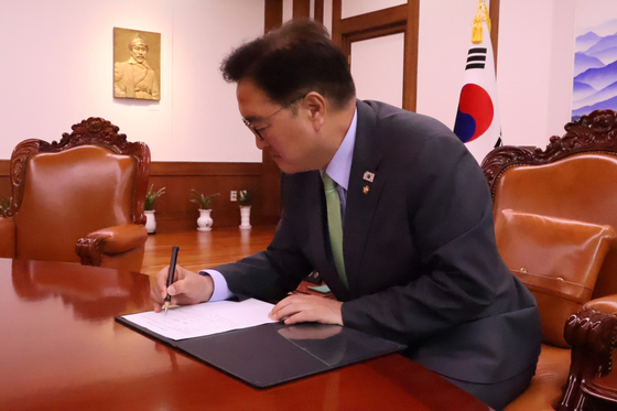 우원식 국회의장이 10일 '3대 특검법'(내란특검법·김건희특검법·채상병특검법)에 대한 특별검사 임명 요청 서류에 결재하고 있다. 사진 페이스북 캡처