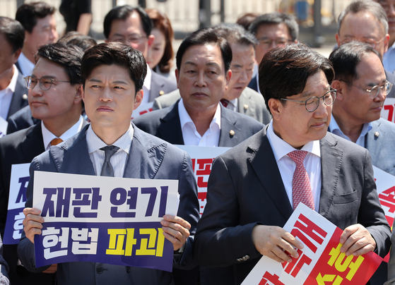 국민의힘 김용태 비상대책위원장과 권성동 원내대표가 11일 이재명 대통령의 공직선거법 위반 사건의 파기환송심을 사실상 무기한 연기한 서울고등법원 앞에서 열린 현장 의원총회를 마무리 하고 있다. 연합뉴스