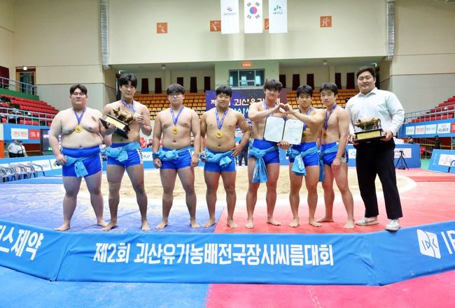 박병훈 감독이 이끄는 영신고가 12일 충북 괴산군 괴산문화체육센터에서 열린 ‘제2회 괴산유기농배전국장사씨름대회 고등부 단체전 결승(팀 간 7전 4선승제/개인 간 3전 2선승제)에서 춘천기계공업고를 4-2로 제압하며 우승 트로피를 들어 올렸다. / 대한씨름협회