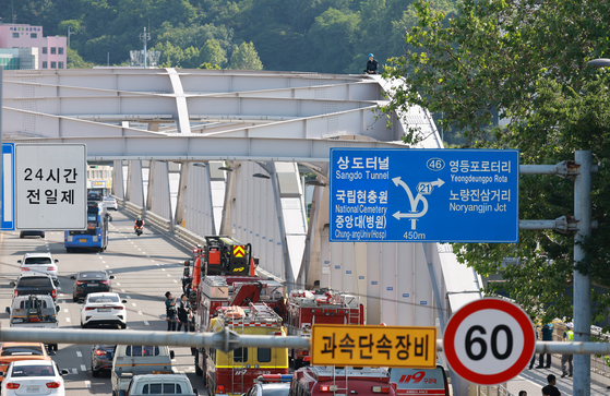 11일 서울 한강대교 아치 위에 오른 A 보육원 출신 송모 씨가 과거 보육원에서 폭력을 당한 피해자들에 대해 국가와 지방자치단체의 배상 및 보상을 촉구하며 농성을 벌이고 있다. 연합뉴스