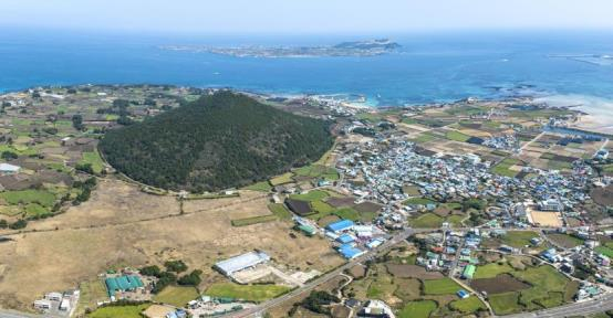 우도를 배경으로 우뚝 솟은 제주 오름 지미봉. 사진 제주자연문화유산연구회