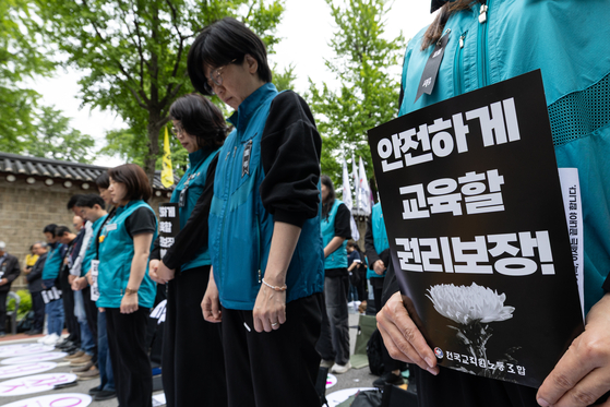 지난달 24일 서울 종로구 경복궁 영추문 인근에서 열린 전국교직원노동조합(전교조) 창립 36주년 전국교사결의대회에서 참가자들이 교권보장법 개정, 안전하게 교육할 권리, 교사 교육권, 교육공공성 강화 등을 촉구하며 민중의례하고 있다. 뉴스1
