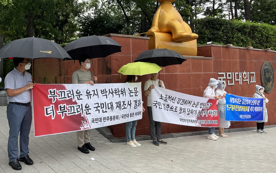 지난 2022년 8월, 국민대 정문 앞에서 국민대 동문 비상대책위원회가 윤석열 대통령 부인 김건희 여사가 2007년 쓴 박사학위 논문조사 결과에 항의하는 현수막을 들고 시위를 하고 있다. 연합뉴스