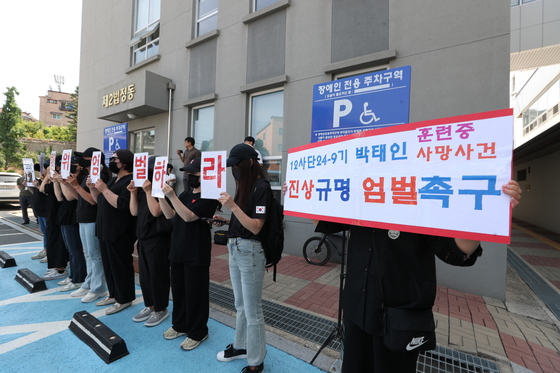 육군 12사단 훈련병 사망사건과 관련해 규정을 위반한 군기훈련(얼차려)을 실시한 지휘관에 대한 영장실질심사가 지난해 6월 열릴 당시 법원을 찾은 군인 자녀를 둔 부모들이 엄벌을 촉구하는 피켓을 들고 서 있다. [연합뉴스]