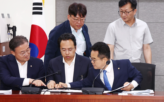  더불어민주당 을지로위원회 민병덕 위원장(앞줄 오른쪽)과 김범석 우아한형제들 대표(가운데)가 19일 오전 서울 여의도 국회에서 배달앱(배달의민족) 사회적대화기구 중간합의문 발표 브리핑에서 중간합의문에 서명하고 있다. 뉴스1