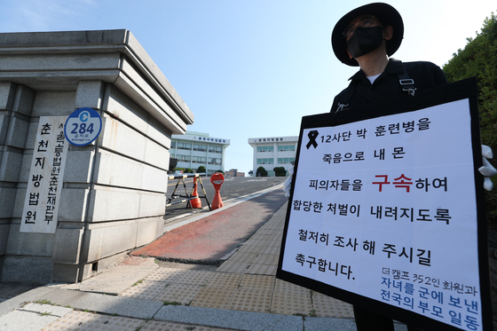 육군 12사단 훈련병 사망사건과 관련해 규정을 위반한 군기훈련(얼차려)을 실시한 혐의를 받는 지휘관의 대한 구속 전 피의자 심문 당시 군인 자녀를 둔 부모가 피의자들의 구속을 촉구하는 1인 시위를 하고 있다. [연합뉴스]