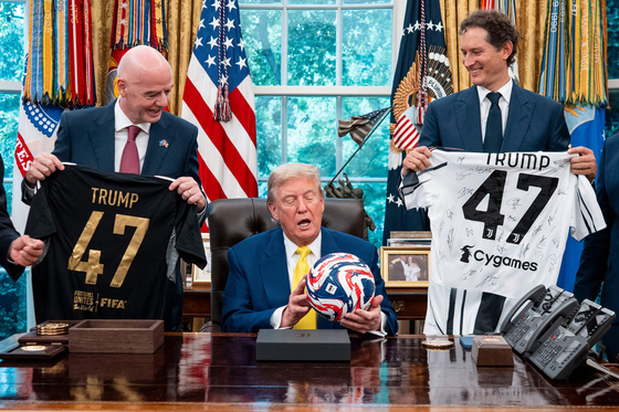 트럼프 대통령(가운데)에게 클럽월드컵 공인구를 선물한 인판티노 FIFA 회장(왼쪽). AFP=연합뉴스