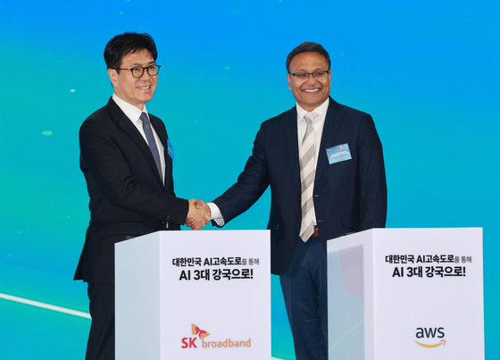 박진효 SK브로드밴드 사장과 아마존웹서비스(AWS) 프라사드 칼야나라만 인프라 총괄 대표가 20일 울산전시컨벤션센터에서 열린 울산 인공지능(AI) 데이터 센터 출범식에서 '울산 AI데이터센터 건립 계약 서명식'을 마친 뒤 악수하고 있다. 사진 대통령실통신사진기자단