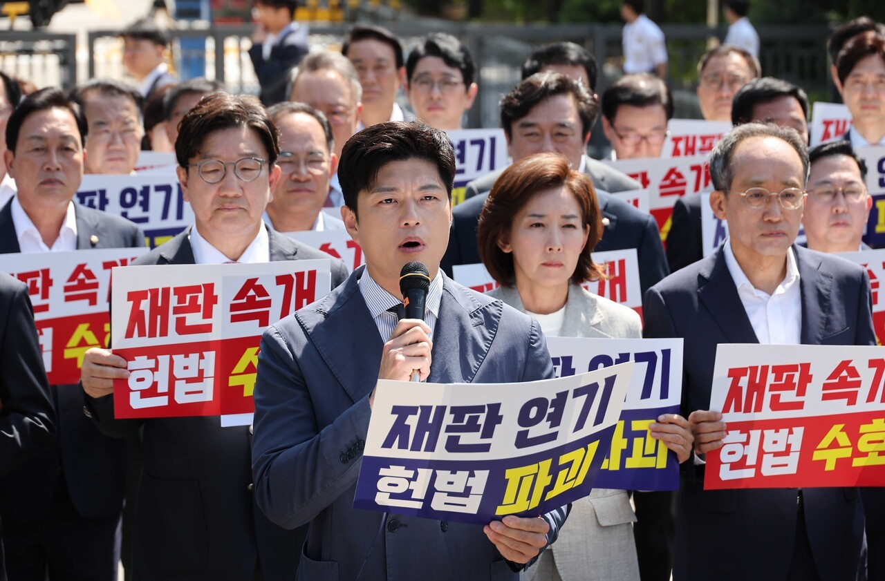 국민의힘 김용태 비상대책위원장(가운데)이 6월 11일 이재명 대통령의 공직선거법 위반 사건의 파기환송심을 사실상 무기한 연기한 서울고등법원 앞에서 열린 현장 의원총회에 참석해 발언하고 있다. [연합뉴스]