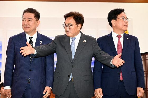 우원식 국회의장이 24일 오전 서울 여의도 국회에서 김병기 더불어민주당 당대표 직무대행 겸 원내대표와 송언석 국민의힘 원내대표와 대화하기에 앞서 기념사진을 찍은 뒤 다른 배석자들도 부르고 있다. 김성룡 기자