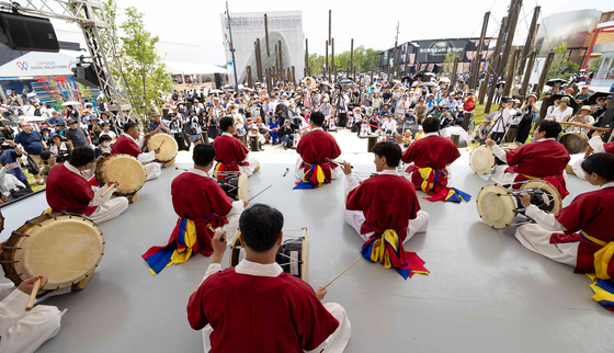 지난 22일, 일본 오사카에서 진행 중인 ‘2025 오사카엑스포’ 야외 팝업스테이지에서 크라운해태제과 임직원들이 ‘사물놀이 삼도농악가락’을 공연하고 있다. 사진 크라운해태제과