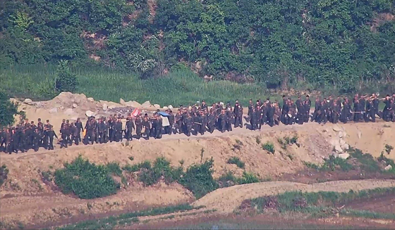합동참모본부는 북한이 4월경부터 북방한계선 등 전선지역 수 개소에서 다수병력을 투입해 경계력 보강 일환 불모지 조성, 지뢰매설, 전술도로 보강, 대전차 방벽으로 보이는 미상 구조물 설치 등 다양한 형태의 작업을 진행 중이라고 18일 밝혔다. 사진은 대규모 북한군이 전선지역에 투입된 모습 . 뉴스1