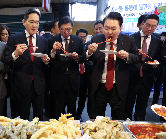 윤석열 전 대통령이 2023년 12월 6일 부산 중구 깡통시장에서 재계 총수들과 함께 떡볶이 등 분식을 맛보고 있다. 오른쪽부터 구광모 LG그룹 회장, 윤 전 대통령, 박형준 부산시장, 이재용 삼성전자 회장. 연합뉴스