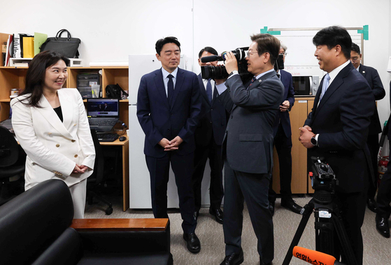 이재명 대통령이 12일 용산 대통령실 청사 영상기자실에서 ENG카메라를 메고 강유정 대변인을 촬영하고 있다. 강 대변인은 대출 6억 제한 조치에 대한 입장을 묻자 "기획재정부에서 나온 대책으로 알고 있는데, 일단 대통령실 대책이 아니다"라고 답변해 야당은 책임회피성 태도라고 비판했다.[대통령실사진기자단] 
