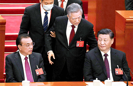 2022년 10월 베이징 인민대회당에서 열린 제20차 공산당 전국대표대회 폐막식에서 수행원에 이끌려 퇴장 당하는 후진타오 전 국가주석(가운데)이 시진핑 주석에게 무언가 말을 하고 있다. AFP=연합뉴스