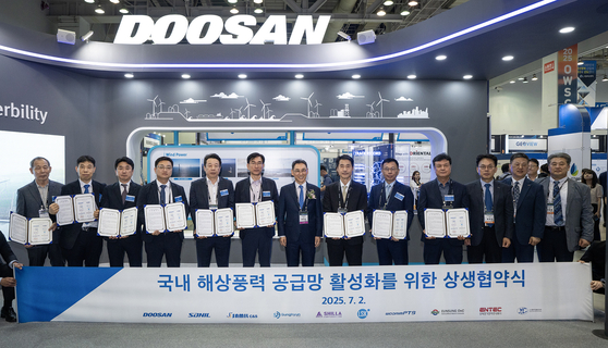 정연인 두산에너빌리티 부회장(가운데)이 ‘2025 해상풍력 공급망 컨퍼런스 전시회’에서 국내 9개 협력사 대표들과 상생협약을 체결하고 기념촬영을 하고 있다. 사진 두산에너빌리티