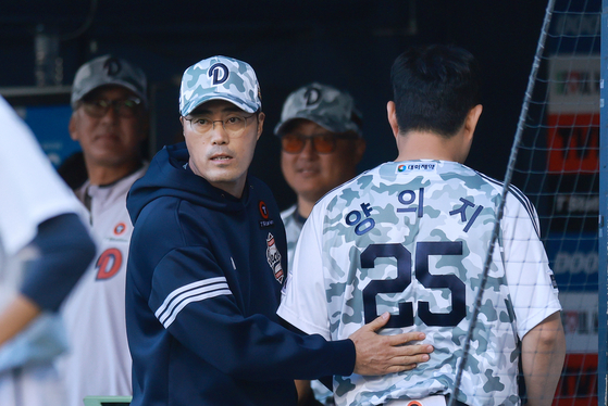 더그아웃으로 돌아온 주전 포수 양의지를 격려하는 두산 조성환 감독대행(왼쪽). [연합뉴스]