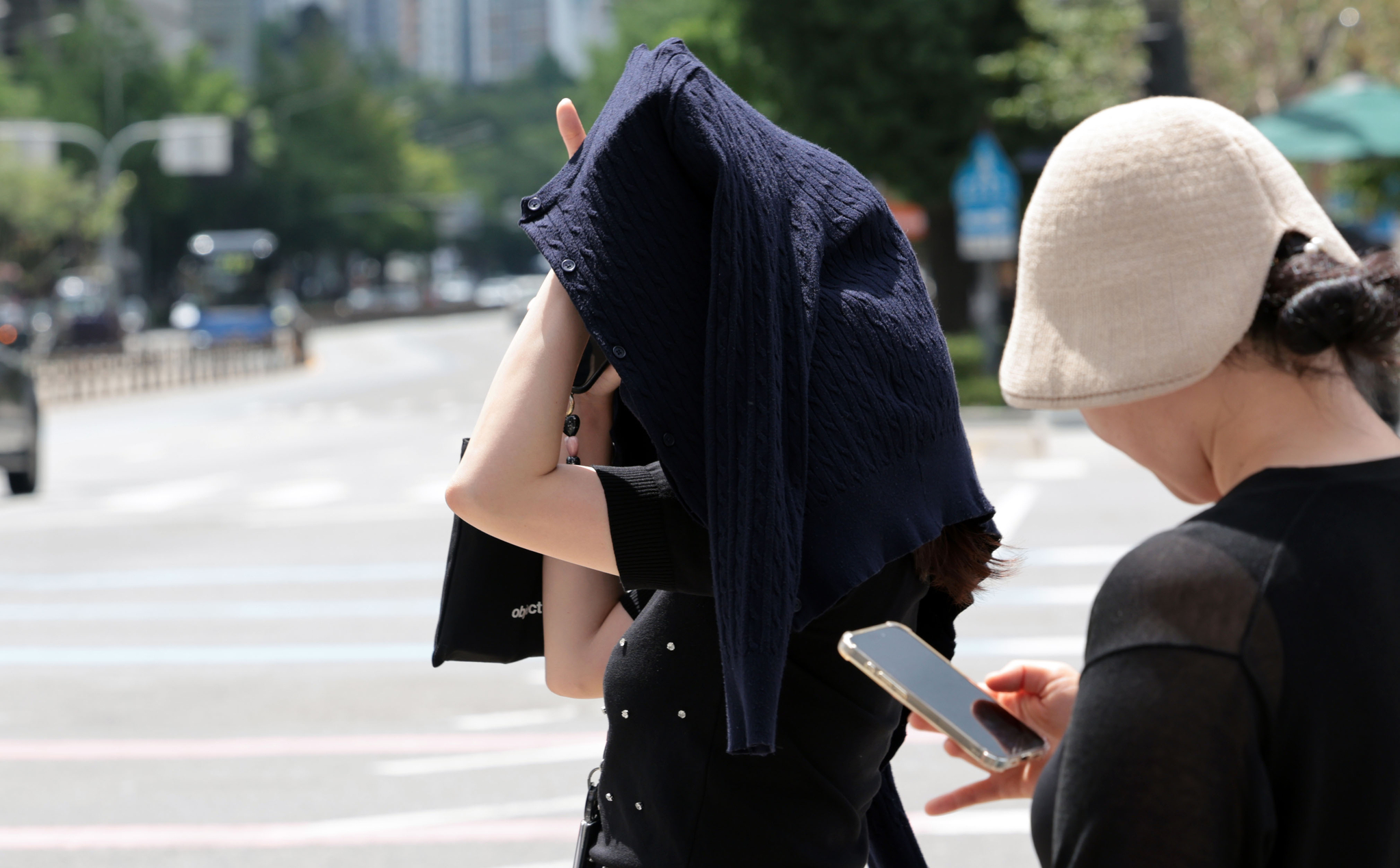 무더운 날씨가 이어지면서 전국 대부분 지역에 폭염특보가 발효된 1일 서울 광화문사거리에서 한 시민이 옷으로 햇볕을 피하고 있다. 연합뉴스