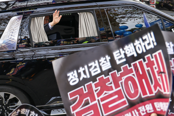 지난해 11월 25일 이재명 당시 더불어민주당 대표가 서울 서초동 서울중앙지법에서 열린 위증교사 혐의 사건 1심 선고공판(무죄)이 끝난 뒤 차량에 탑승해 지지아에게 인사하고 있다. 연합뉴스