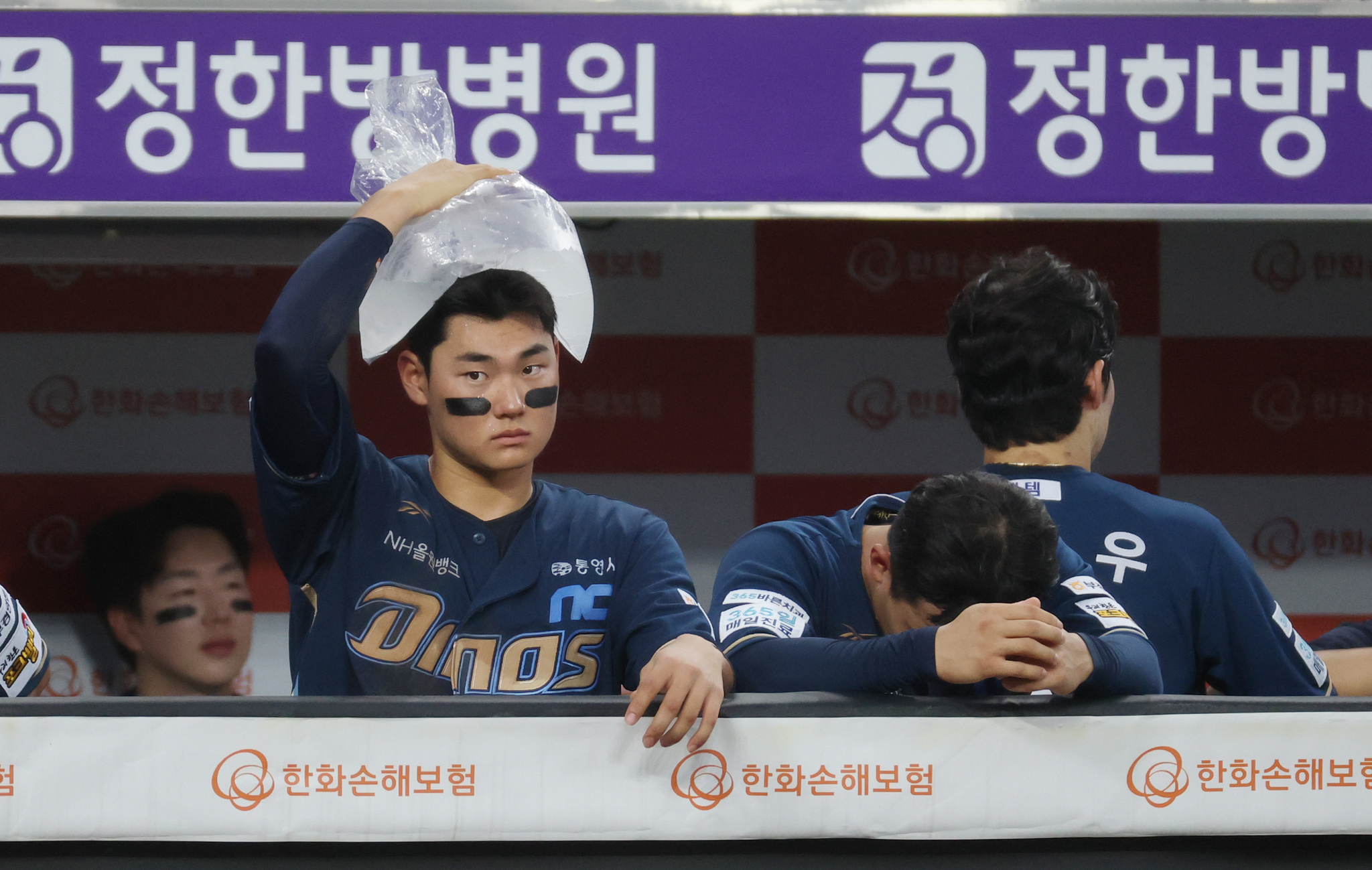 프로야구 NC 김주원이 얼음주머니를 머리 위에 올리고 더위를 식히고 있다. [뉴스1]