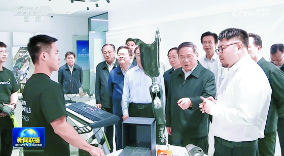 지난 2023년 10월 7~9일 저장성 항저우를 시찰한 리창(오른쪽 앞줄 두번째) 국무원 총리가 브레인코 본사를 찾아 한비청(오른쪽) 창업자에게 궁금한 점을 묻고 있다. CC-TV 캡처
