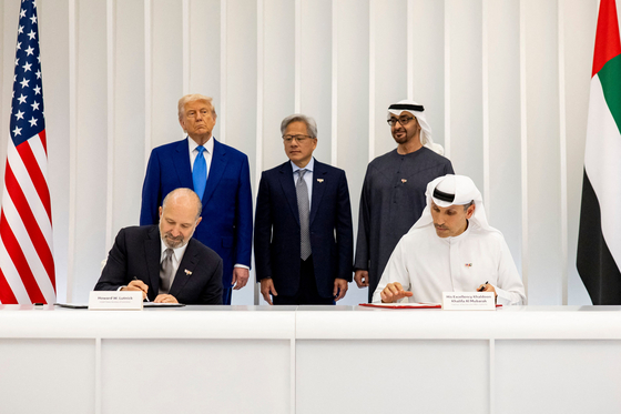 지난 5월 15일(현지시간) 아랍에미리트(UAE) 아부다비에서 하워드 러트닉 미국 상무부 장관과 칼둔 칼리파 알 무바라크 무바달라 최고경영자(CEO, 앞줄 왼쪽부터)가 미국-UAE 인공지능(AI) 가속화 파트너십 협정에 서명하고 있다. 서명을 지켜보는 도널드 트럼프 미국 대통령, 젠슨 황 엔비디아 CEO, 셰이크 모하메드 빈 자이드 알 나흐얀 UAE 대통령(뒷줄 왼쪽부터). AFP=연합뉴스  