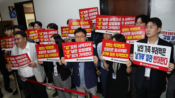 국민의힘 보좌진협의회 보좌관들이 14일 서울 여의도 국회에서 열리는 강선우 여성가족부 장관 인사청문회장 앞에서 강 장관을 규탄하는 손팻말을 들고 있다.뉴스1