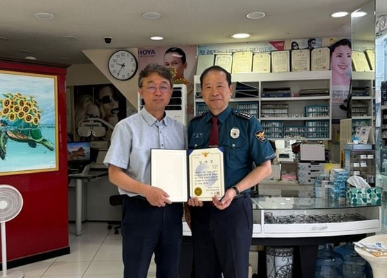 외국인 보이스피싱 수거책을 붙잡은 부산 안경원 점주가 경찰로부터 감사장을 받았다. 사진 부산 서부경찰서
